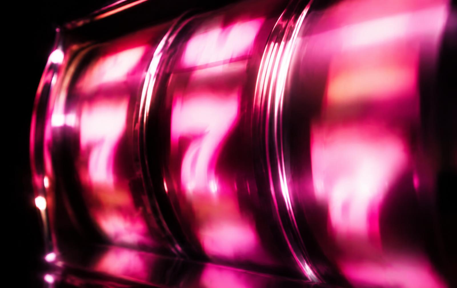 Glowing slot machine reels in neon pink and lime